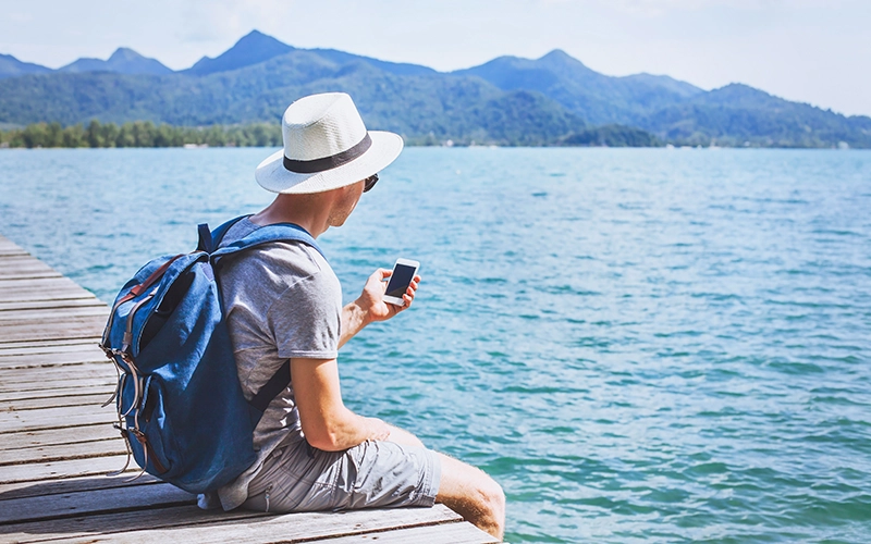 man on a lake looking at phone